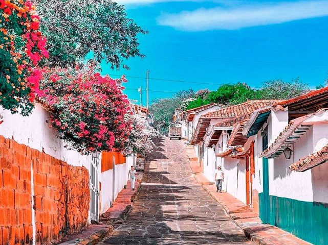 Vista de una calle colonial de Barichara, rodeada de casas tradicionales.