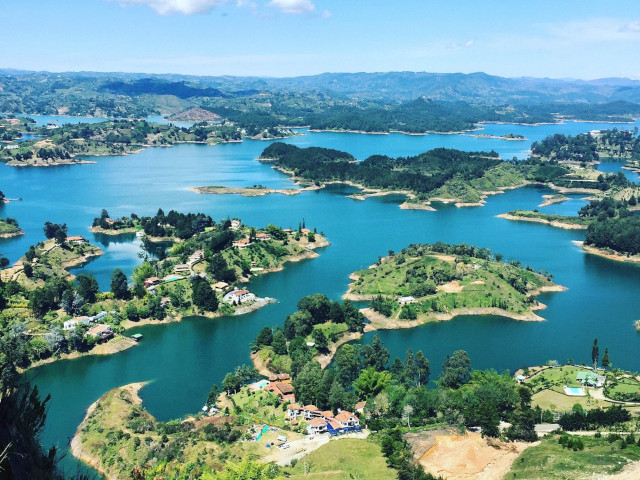 Paisaje del embalse de Guatapé rodeado de montañas y vegetación.