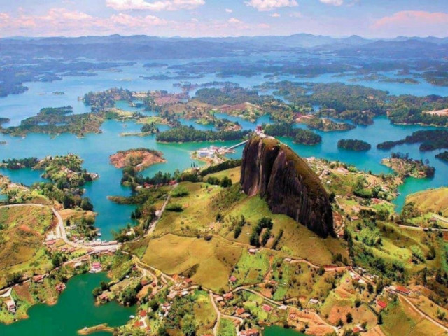Vista panorámica del embalse de Guatapé rodeado de montañas y paisajes naturales.