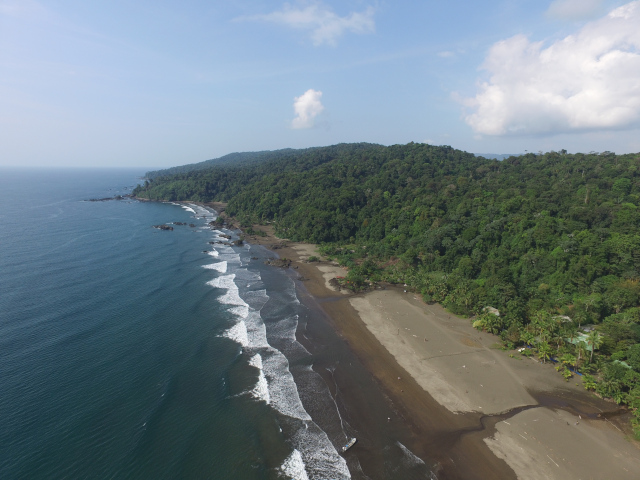 Vista aérea de la costa de Bahía Solano rodeada de selva tropical y playas vírgenes.